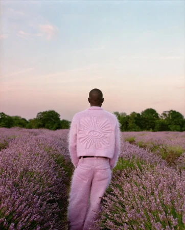 Person wearing a fluffy pink textured matching set standing in a vast lavender field under a soft pastel sky