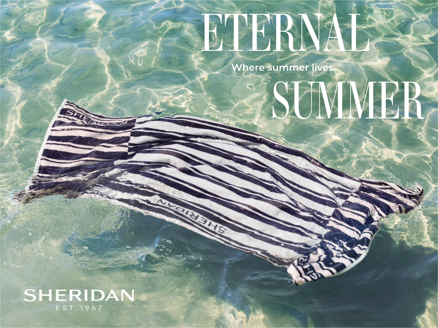 Striped towel floating in clear shallow water with sun caustic patterns underneath