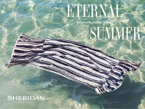 Striped towel floating in clear shallow water with sun caustic patterns underneath