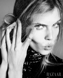 Close-up portrait of model Ida Heiner in a dark sparkly top, touching her hair, shot by Ethan James Green for Harper's Bazaar U.S.