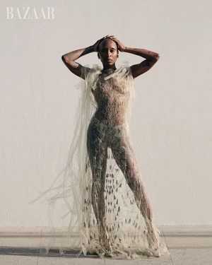 Cynthia Erivo posing in a sheer, textured gown against a plain light wall for Harper's Bazaar U.S.