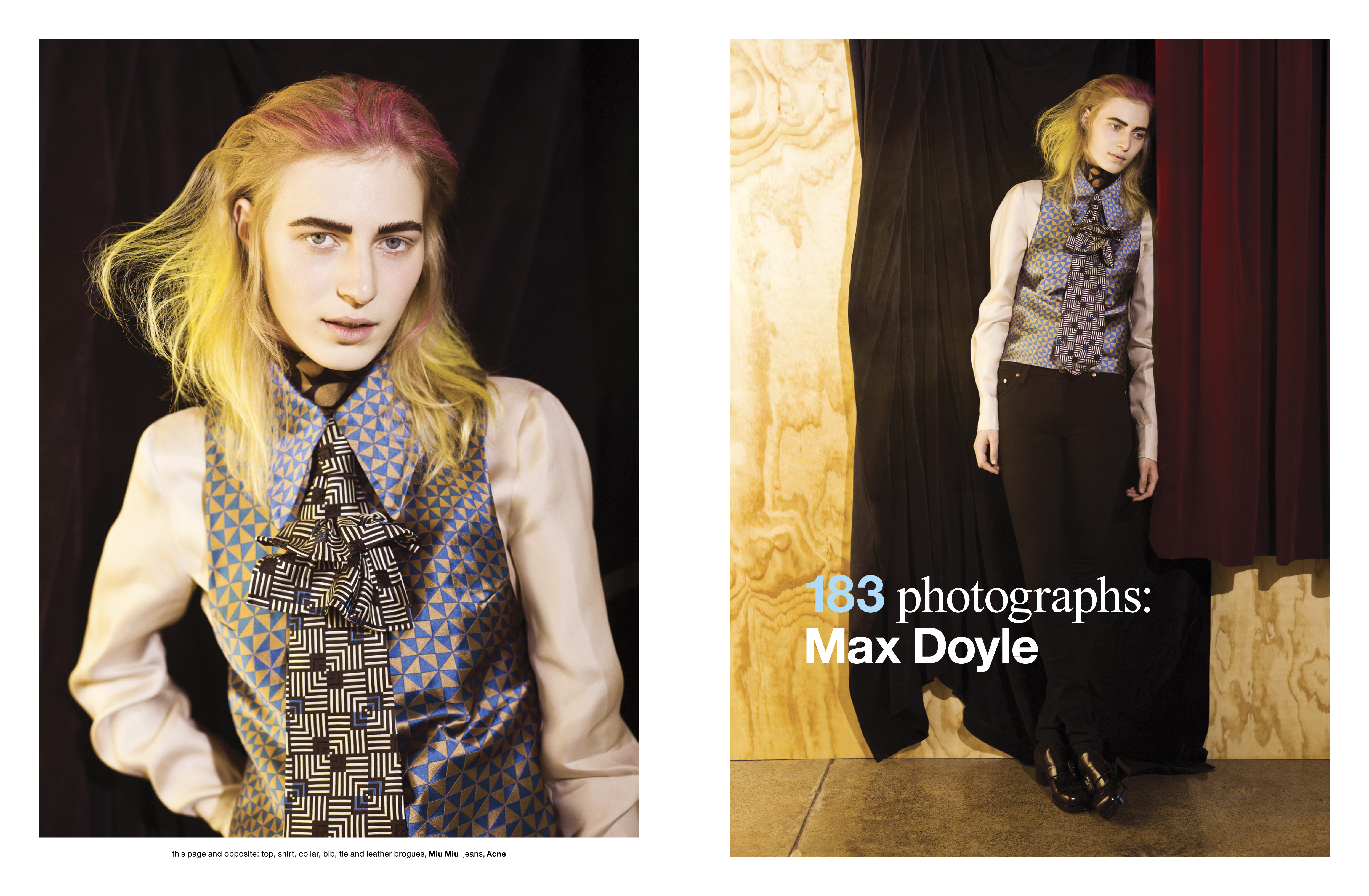 Editorial fashion shot of a young adult woman with rainbow-colored hair, wearing a patterned vest and dress shirt with a bow, in a studio setting.