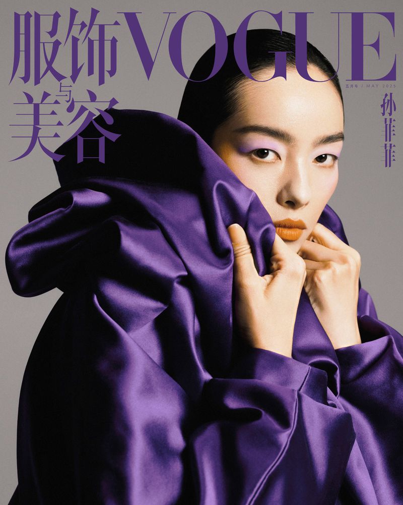 Asian woman in purple satin top and lilac eyeshadow, Vogue cover, studio shot. Makeup, beauty, fashion, and clothing editorial.