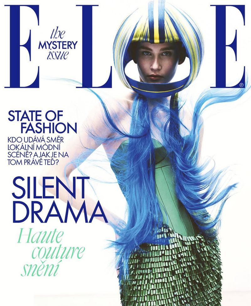Elle Magazine cover featuring a woman in couture fashion with a helmet-like headpiece and turquoise hair strands, against a bright background.