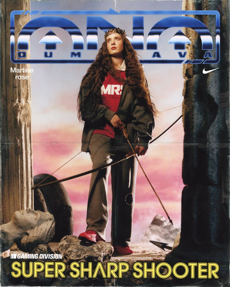 A digital magazine cover features a woman in period attire holding a bow and arrow against a surreal sky and Greco-Roman ruins.