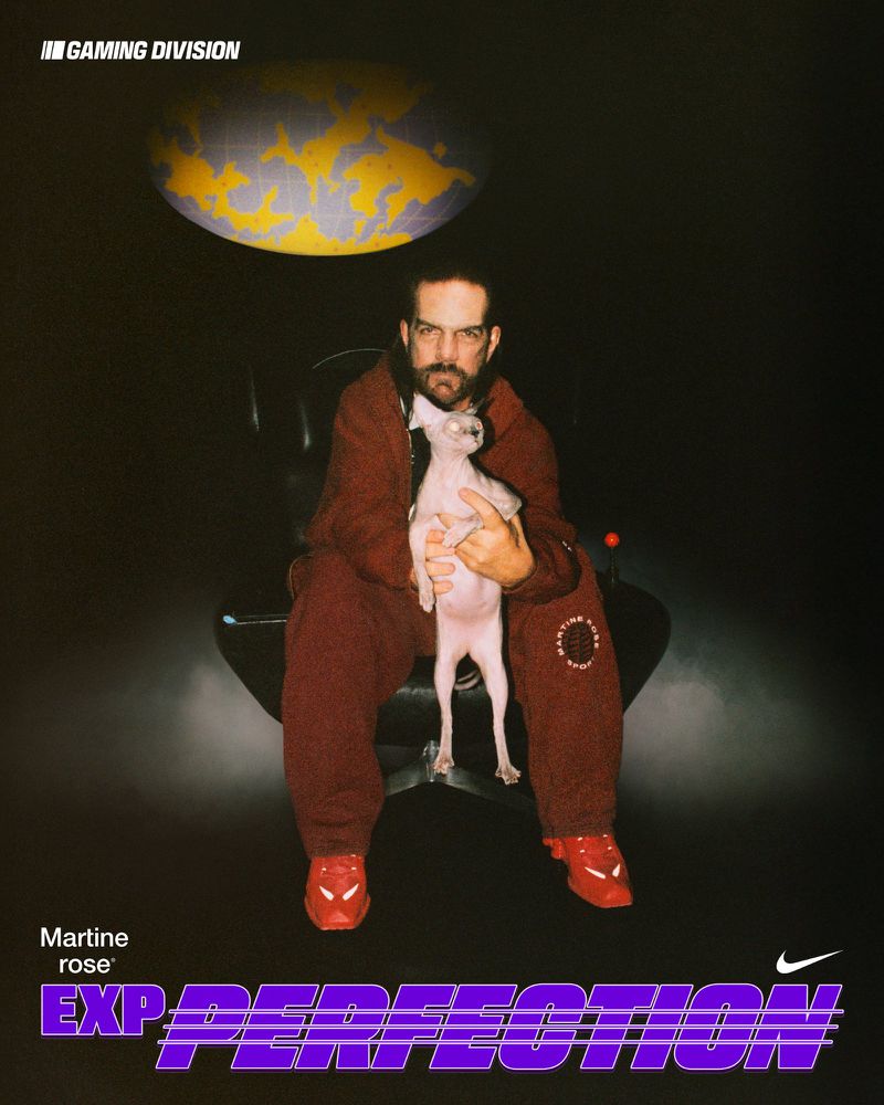 Man in maroon sweatsuit sitting, holding a hairless dog in studio with a globe. EXP PERFECTION text in blue and purple. Nike logo in corner.
