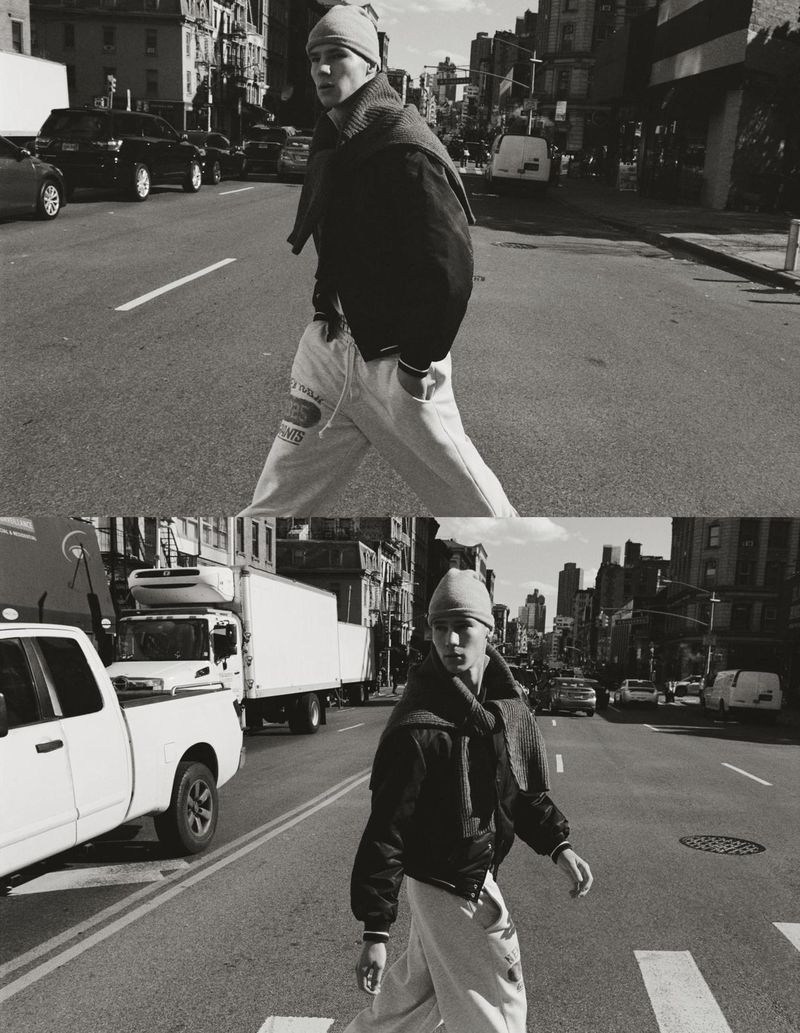 Monochrome portrait of a male model in jacket and beanie crossing urban street, captured in split diptych composition with cars and trucks.