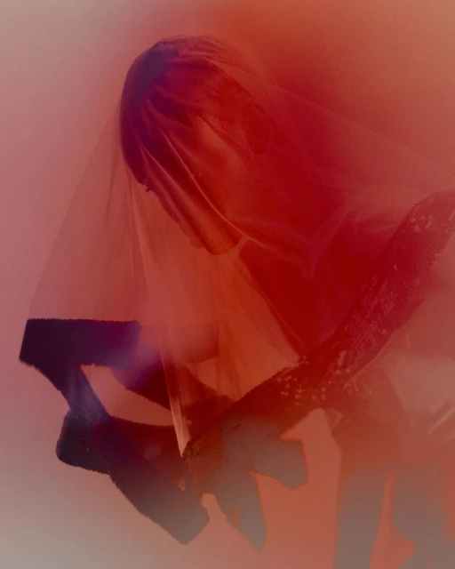 Surreal artistic portrait of a person draped in sheer red fabric, highlighted by striking red and orange tones.