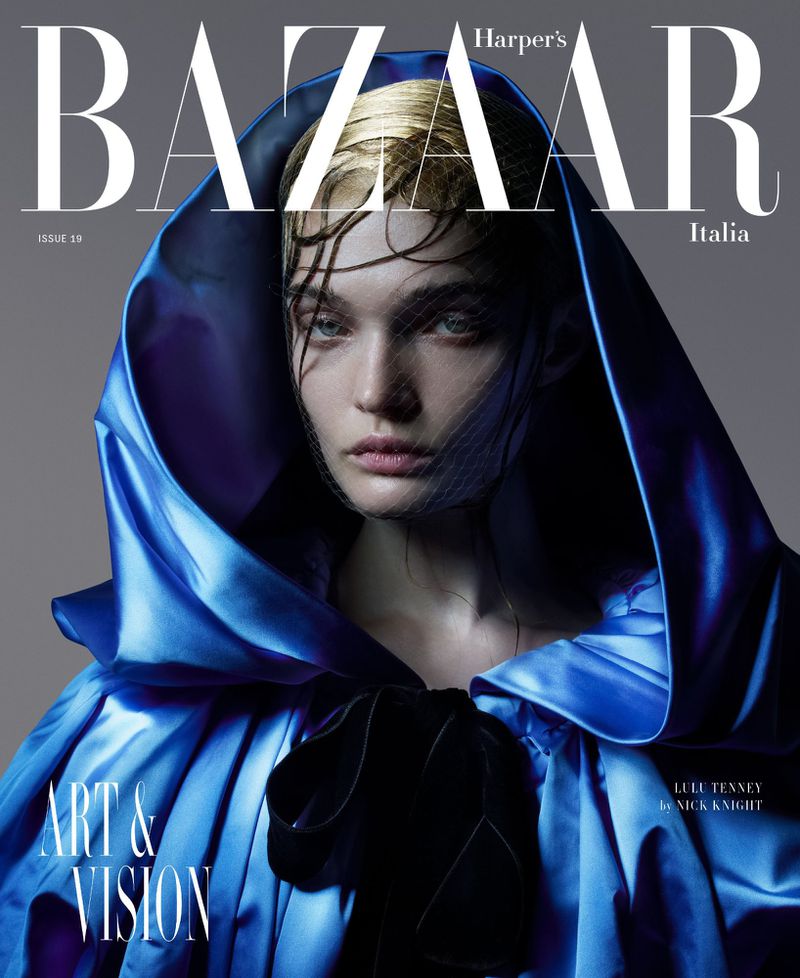 Harper's Bazaar Italia magazine cover featuring a woman with blonde hair and a blue satin hooded cape, shot in a photo studio.