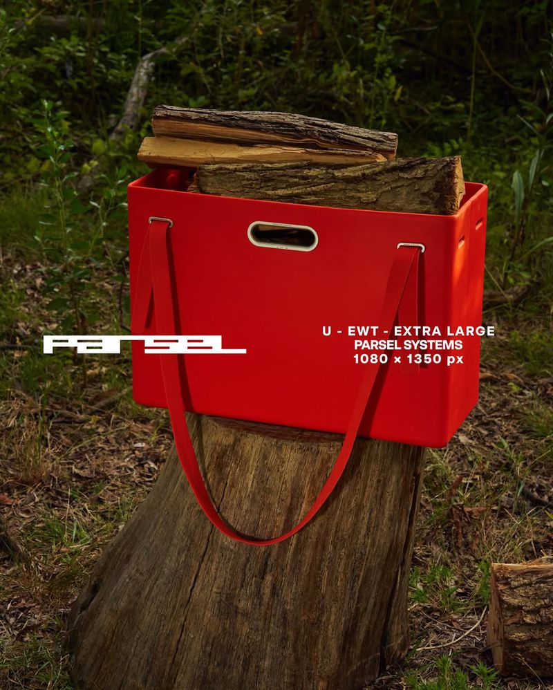 Red tote bag filled with firewood sits on a tree stump in a forest setting, showcasing outdoor functionality and rustic charm.