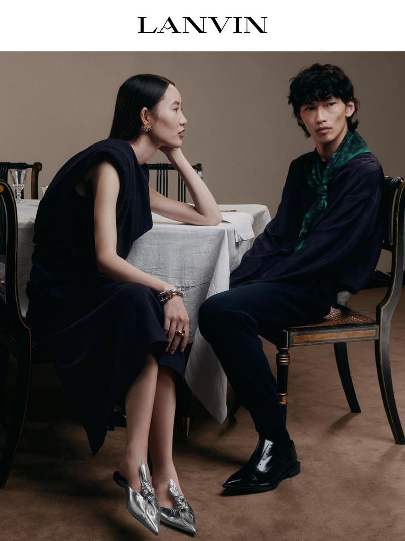 Fashion editorial featuring an Asian female model seated at a table and an Asian male model seated at a table wearing Lanvin apparel.