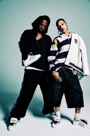 Two models posing against a grey gradient studio background for an Adidas and Avirex collaboration campaign