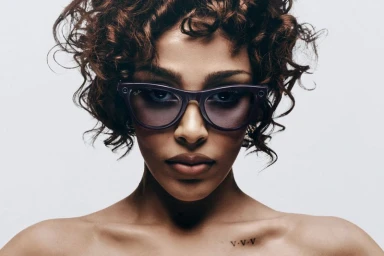 Close-up portrait of Doja Cat wearing purple Ray-Ban Meta smart glasses against a plain white background.