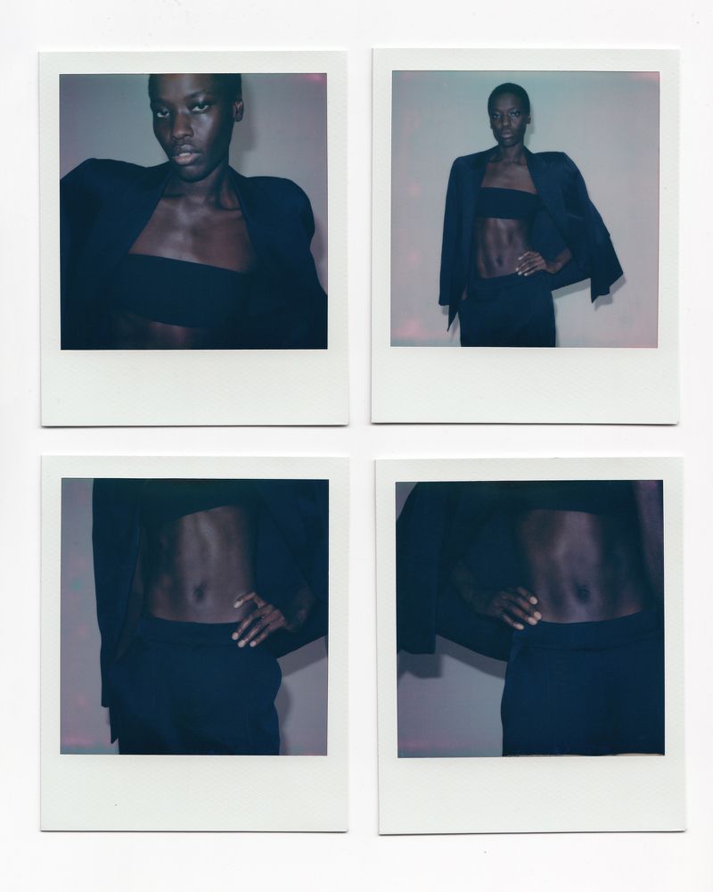 Four polaroid photos featuring an African-American fashion model wearing a black blazer and matching tube top and pants against a neutral backdrop.