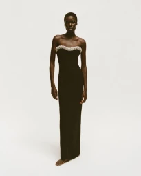Model Awar Odhiang in a black strapless gown with a crystal neckline against a plain white background for Simkhai.