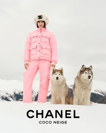 Chanel Coco Neige fashion ad featuring a woman in a pink ski suit, furry hat with a logo, and two husky dogs in a snowy mountain setting.