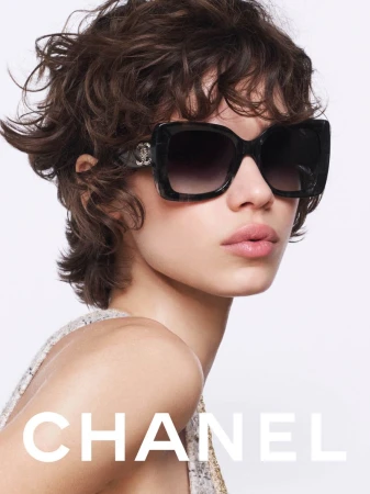 Model wearing oversized dark sunglasses and a textured top against a white background for Chanel Eyewear F/W 2025 Campaign