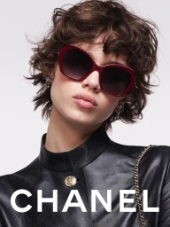 Model wearing dark red sunglasses and a black leather jacket against a white background for Chanel Eyewear.
