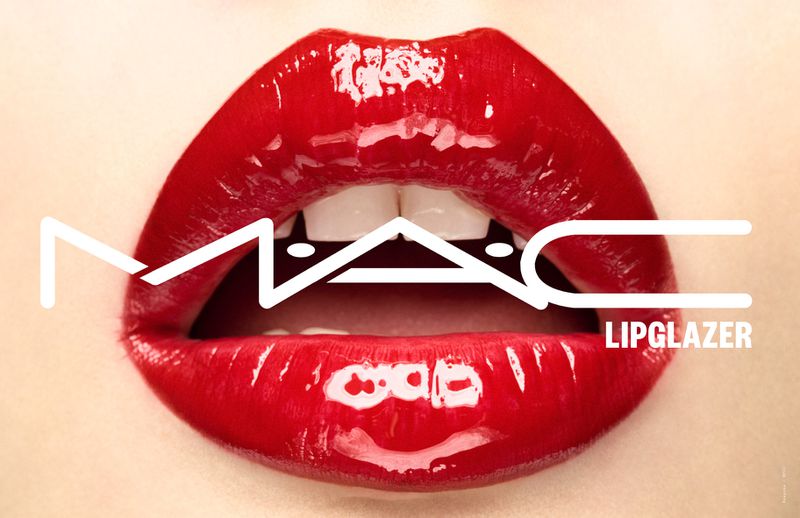 Macro shot of glossy red lips with visible white teeth and the 'MAC Lipglazer' logo, capturing the essence of beauty and makeup.