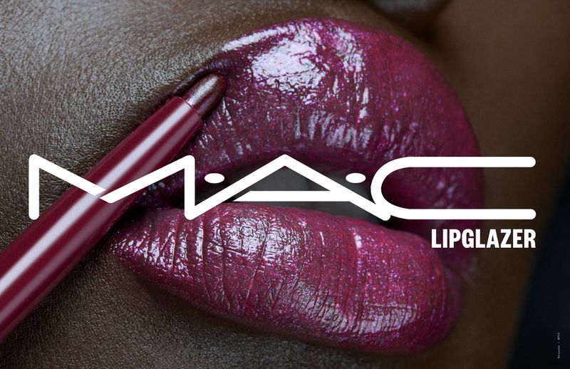 Close-up of an adult female with dark skin and purple lipstick, holding a matching lip pencil, featuring the MAC logo and 'Lipglazer' text.