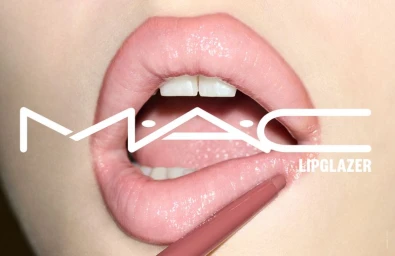 Close-up macro shot of glossy pink lips with a lip pencil being applied, featuring MAC Lipglazer branding overlay.