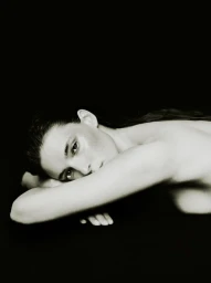 Model resting head on arms against a dark background for the AUNU Beauty Campaign shot by Sonia Szostak