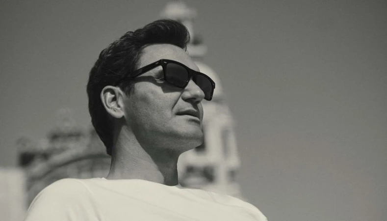 Roger Federer wearing black sunglasses and a white t-shirt in a black and white portrait photographed by Gregory Harris for Oliver Peoples.