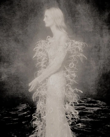 Model Jojo Schneider in a white feathered couture gown shot by Szilveszter Mako for the Phan Huy campaign