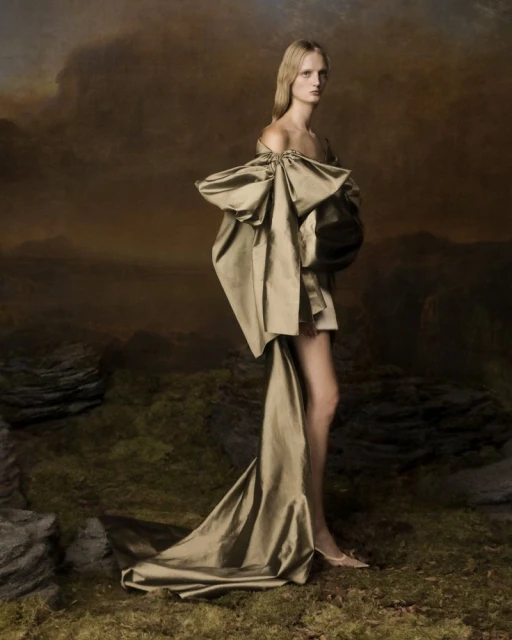Fashion shot of a woman in a couture dress with an artistic landscape background, creating an editorial and elegant image.