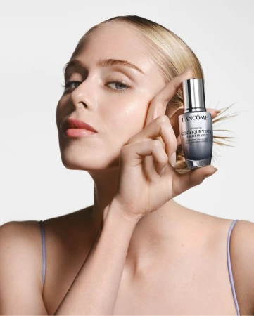 Blonde woman with fair skin poses with Lancome Genifique eye serum in studio, minimalist aesthetic, beauty and skincare product promotion.