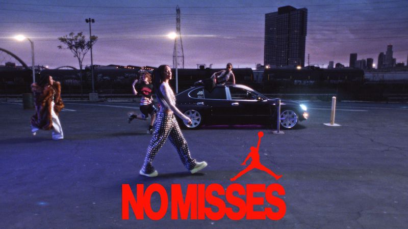 Urban fashion shoot with diverse group of adults in a parking lot at dusk, featuring contemporary streetwear styles and a sedan.