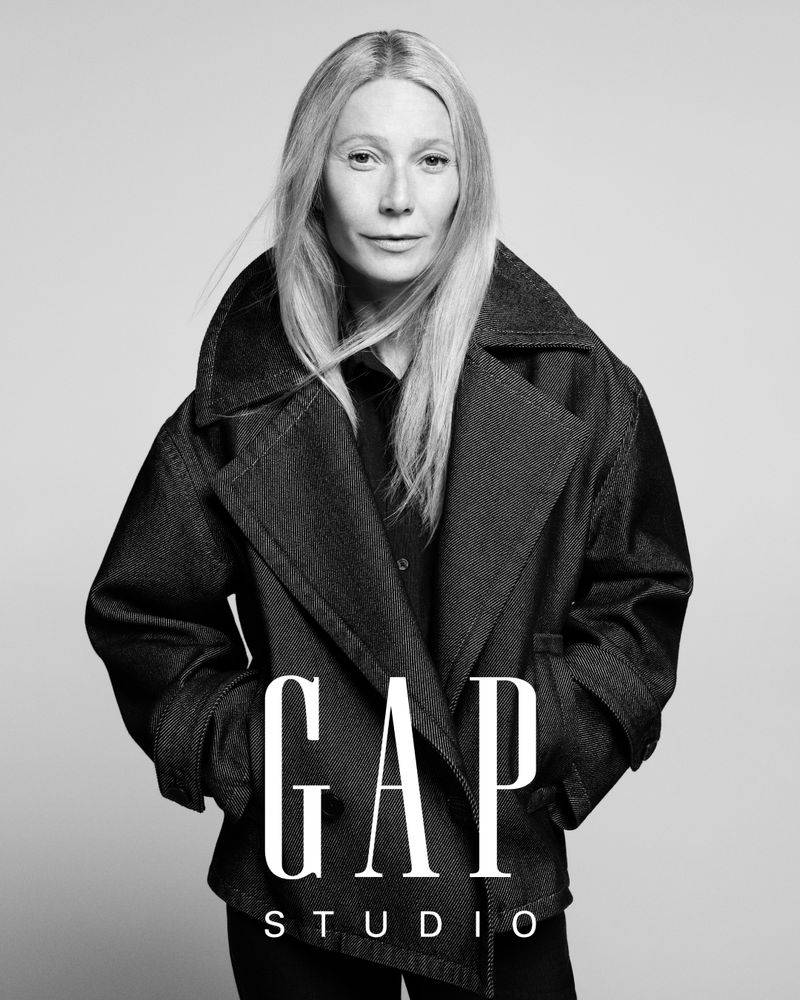 Black and white portrait of a woman wearing a jacket, with GAP Studio logo in the foreground, conveying a fashion-forward aesthetic.