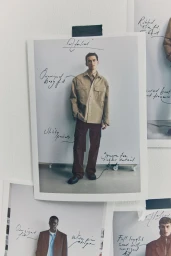 Behind the scenes lookbook print taped to a mood board wall with handwritten styling notes for H&M Atelier A/W 2025.