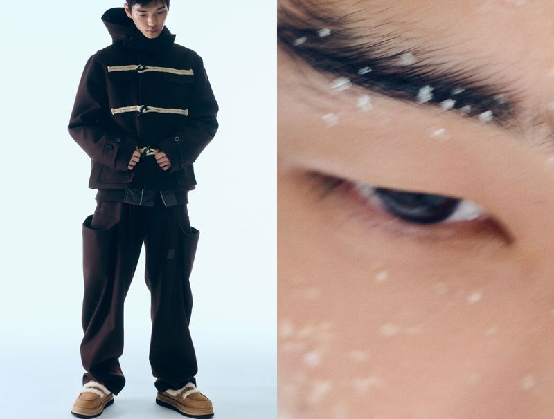 A young adult male model poses in a studio wearing a brown hooded jacket and matching baggy pants paired with light-brown moccasins with shearling.