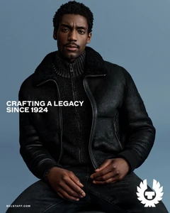 Model Halid Nuhu wearing a black leather jacket and ribbed turtleneck against a solid blue background.