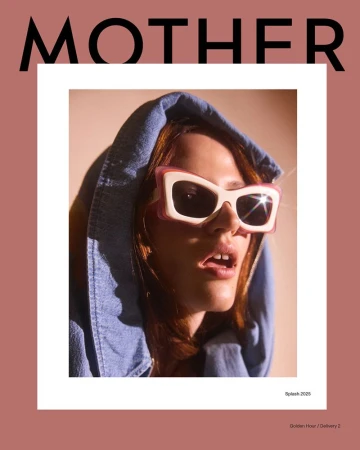 Close-up of a woman with red hair wearing sunglasses and a denim hoodie, set against a peach background with the word 'MOTHER' above.
