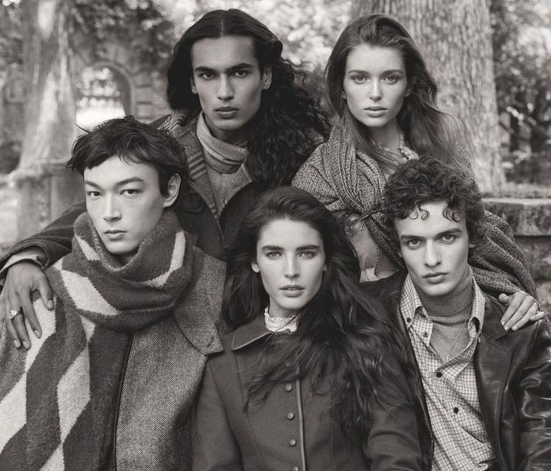 Black-and-white portrait featuring five young adult models posing outdoors with soft, natural light and classic styling in a rural setting.