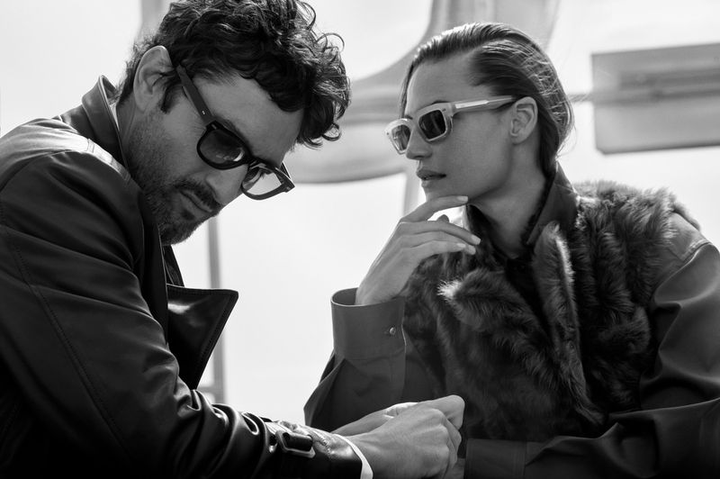 Black and white portrait of a man and a woman wearing stylish sunglasses and textured outerwear for the Brunello Cucinelli Eyewear F/W 2025 Campaign