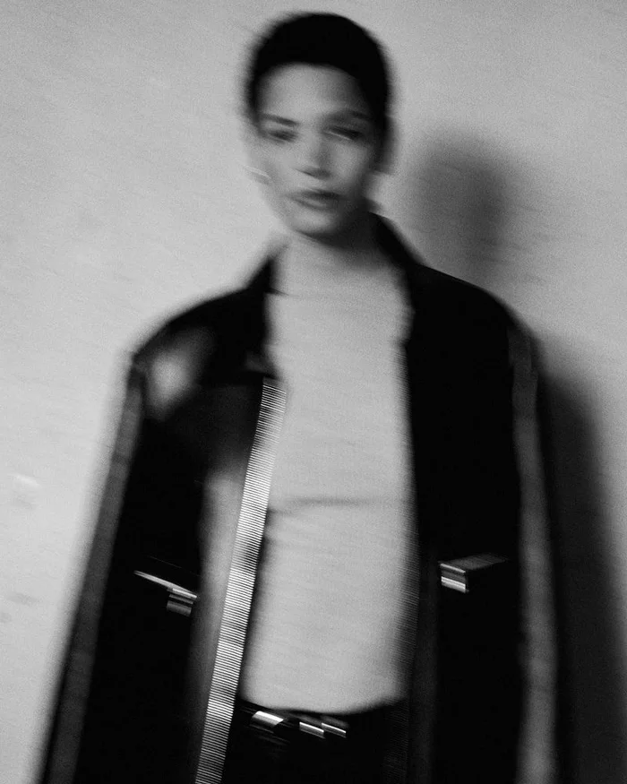 Model Laiza de Moura wearing a dark jacket and light top in a blurred black and white editorial portrait by Paul Scala