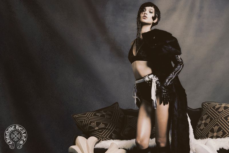 An adult female in a bra and shorts is shown in a studio setting with a fur coat, accessories, and decorative sofa.