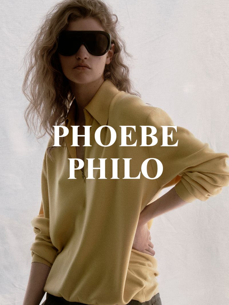 Fashion editorial shot of a woman posing in sunglasses and a yellow shirt against a white backdrop, showcasing modern style and design.
