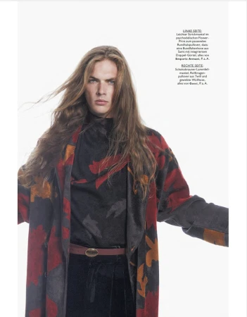 Long-haired male model wearing a patterned red and black coat against a bright white background for Monsieur Magazin Germany