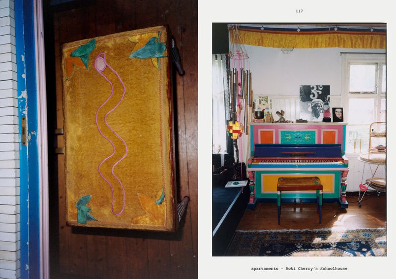 Vintage photograph of a brightly painted upright piano indoors with colorful decor and antique furniture, offering a glimpse into an eclectic, artistic home.