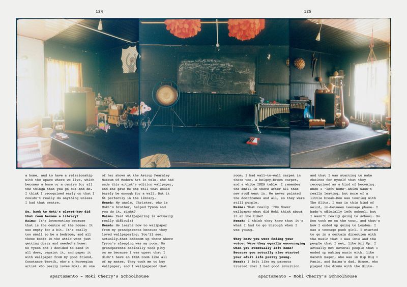 Interior view of Moki Cherry's Schoolhouse displays musical instruments, children's toys, and a blackboard inside a carpeted room.