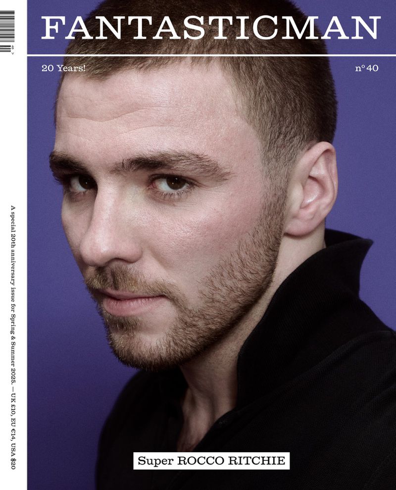 Portrait of Rocco Ritchie on magazine cover with violet background, featuring his head and shoulders in black collared shirt.
