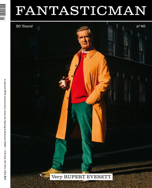 Middle-aged man in orange coat holding coffee cup in urban setting for Fantastic Man magazine cover, celebrating 20 years.