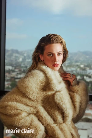 Portrait of Lili Reinhart wearing a fur coat, against a background of city buildings and blue sky, with the 'marie claire' logo in the corner.