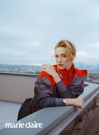 Lili Reinhart wearing a red and patterned top leaning on a rooftop railing against an overcast skyline for Marie Claire U.S.