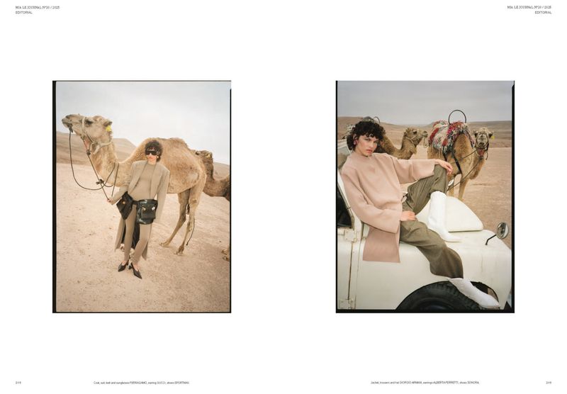 Editorial fashion photography of a female model in a beige outfit posing with camels in the desert wearing sunglasses and holding reins.