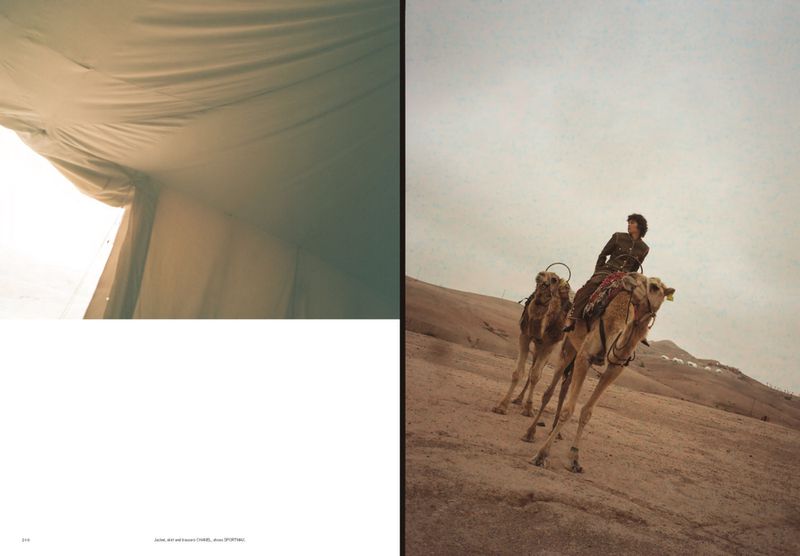 Two-page spread photograph features two camels ridden by a person on sand dunes against a light sky and a white tent interior.